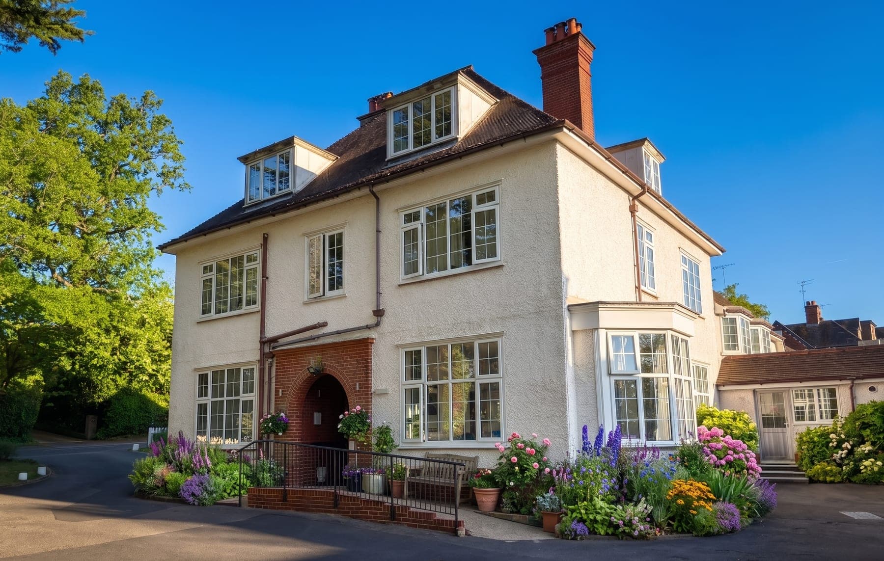 Crossways Residential Care Home, a detached house in Lindfield, with its flower garden in bloom
